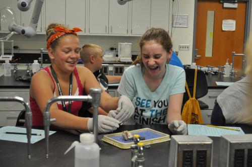 ''Two girls performing a dissection experiment at Exploration Days."