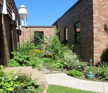 Photo caption: Rain garden beautifies an urban space while collecting and infiltrating roof water. Photo credit: Jane Herbert