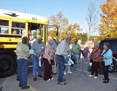 Participants in the annual Alcona County George Byelich Memorial Fall Color Tour get off the bus to visit their next site.