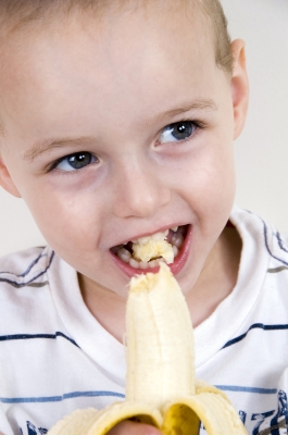 Little boy eating banana