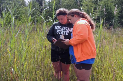 Two girls monitoring aquatic plants image.