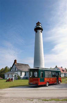 Tour bus in front of lighthouse image.